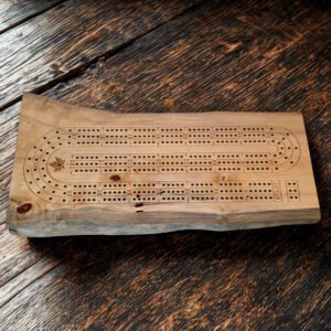 Handcrafted live edge cribbage board made from Mabitoba maple, featuring a classic peg layout and natural wood character.