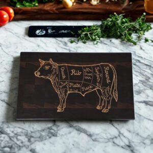 Handcrafted end grain walnut cutting board with butcher-cut cow inlay styled on kitchen counter