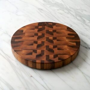 Round end grain cutting board on a marble counter yop.